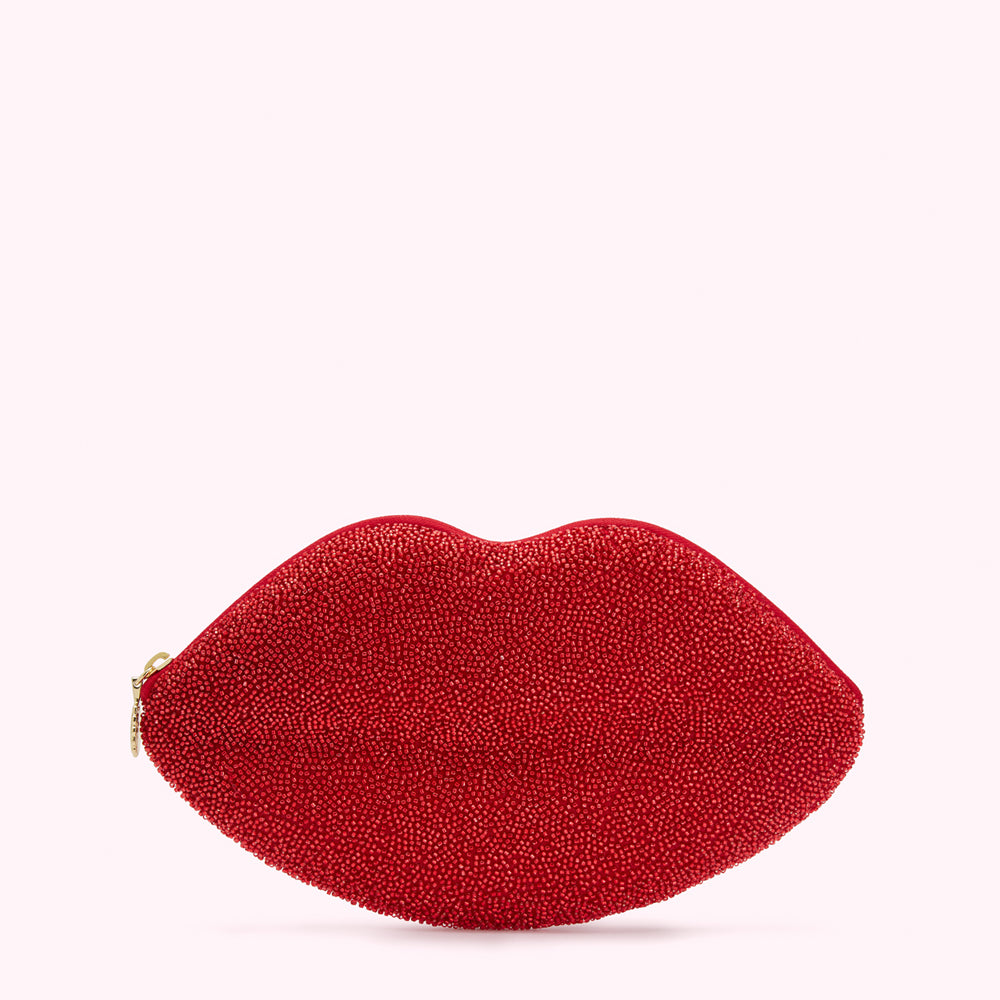 Red beaded lip-shaped clutch on white background.