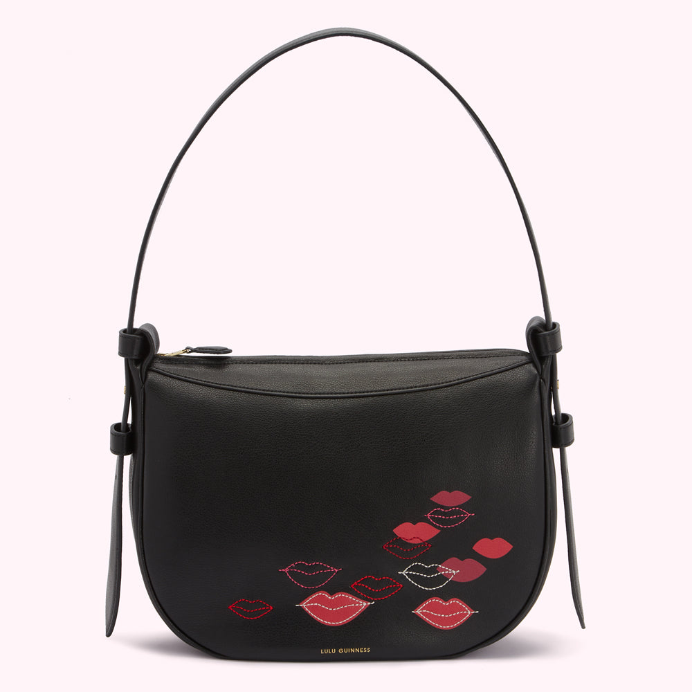 Black Lulu Guinness shoulder bag with red and pink lips embroidered on the front.
