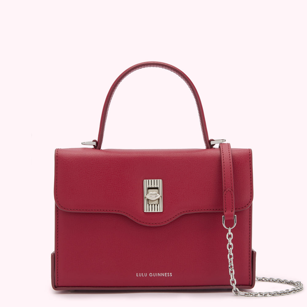 Red Lulu Guinness satchel bag with silver hardware and chain strap.