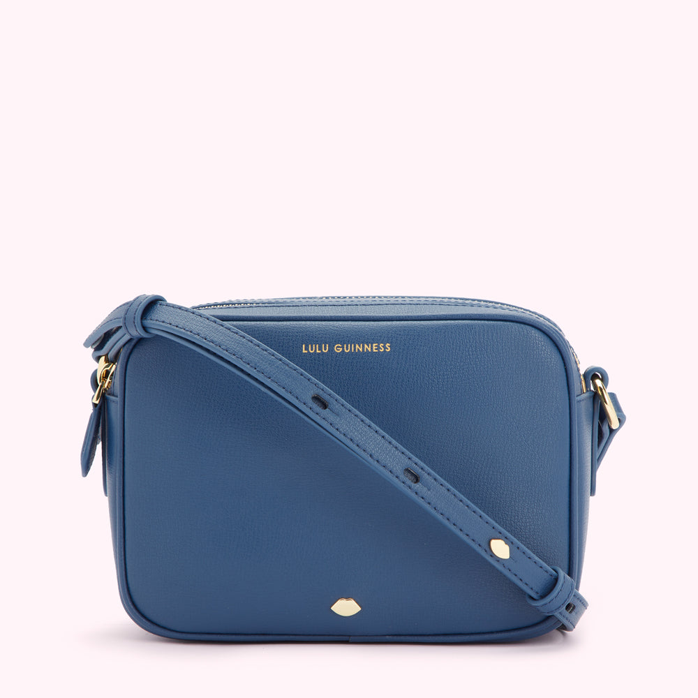 A blue Lulu Guinness crossbody bag with a gold logo and adjustable strap.