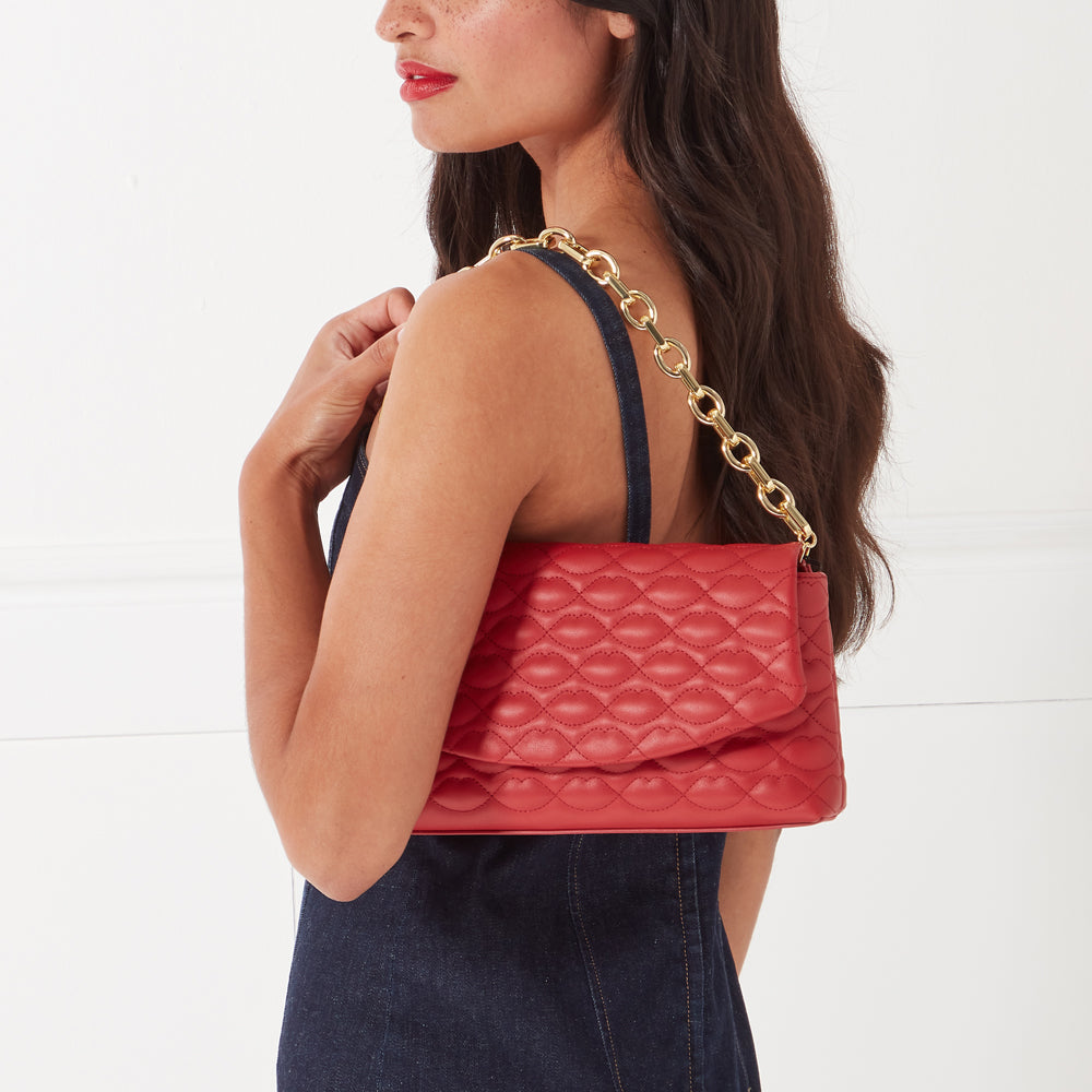 Red quilted crossbody bag with gold chain strap.