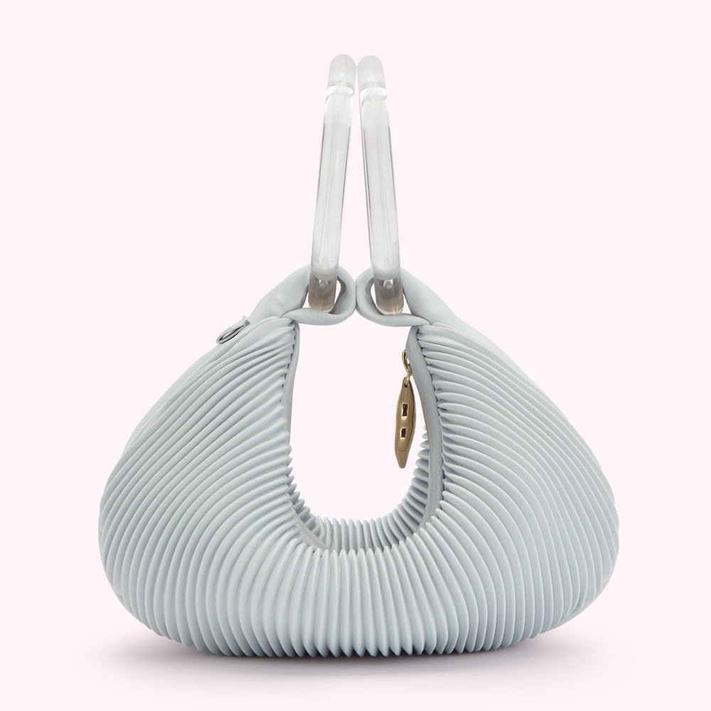 Light blue pleated handbag with clear handles.
