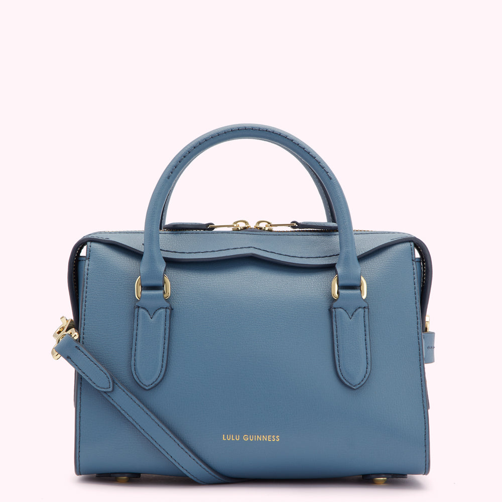 A powder blue Lulu Guinness leather handbag with gold hardware and a crossbody strap.