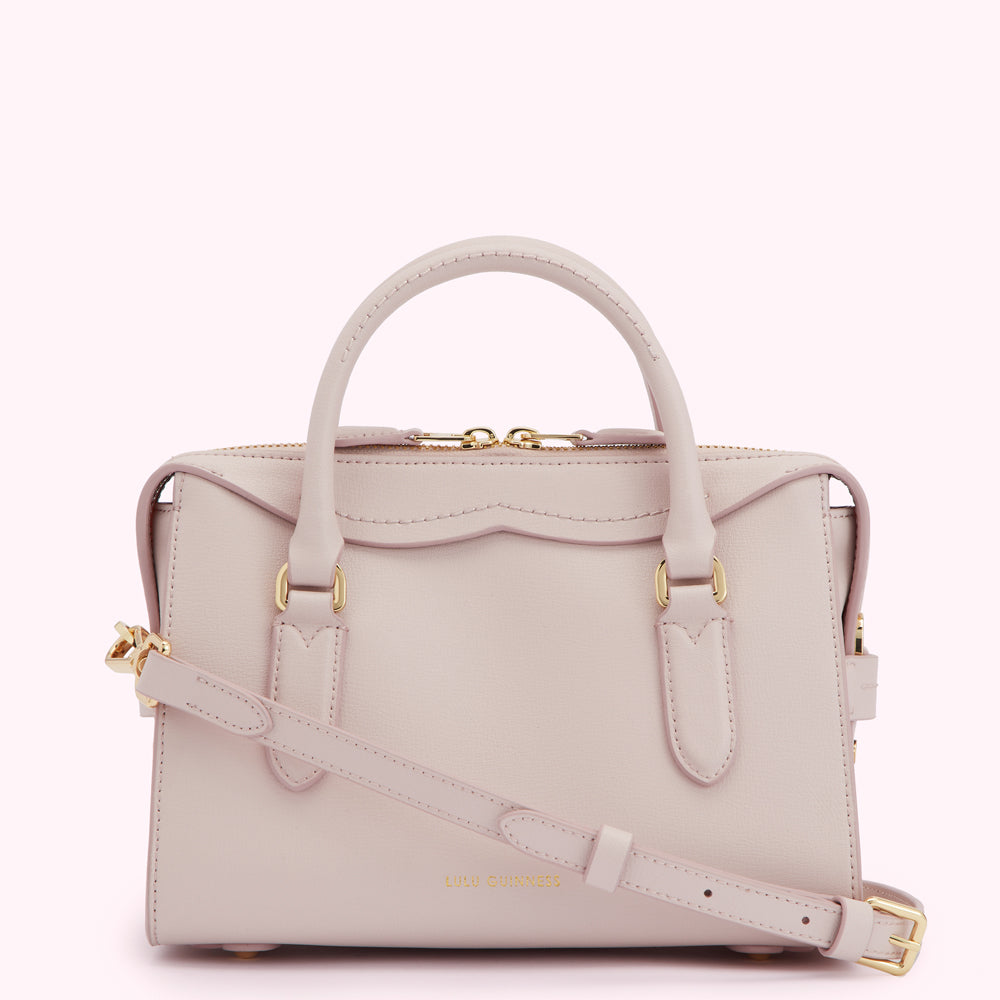A pale pink Lulu Guinness satchel bag with gold hardware and a detachable shoulder strap.