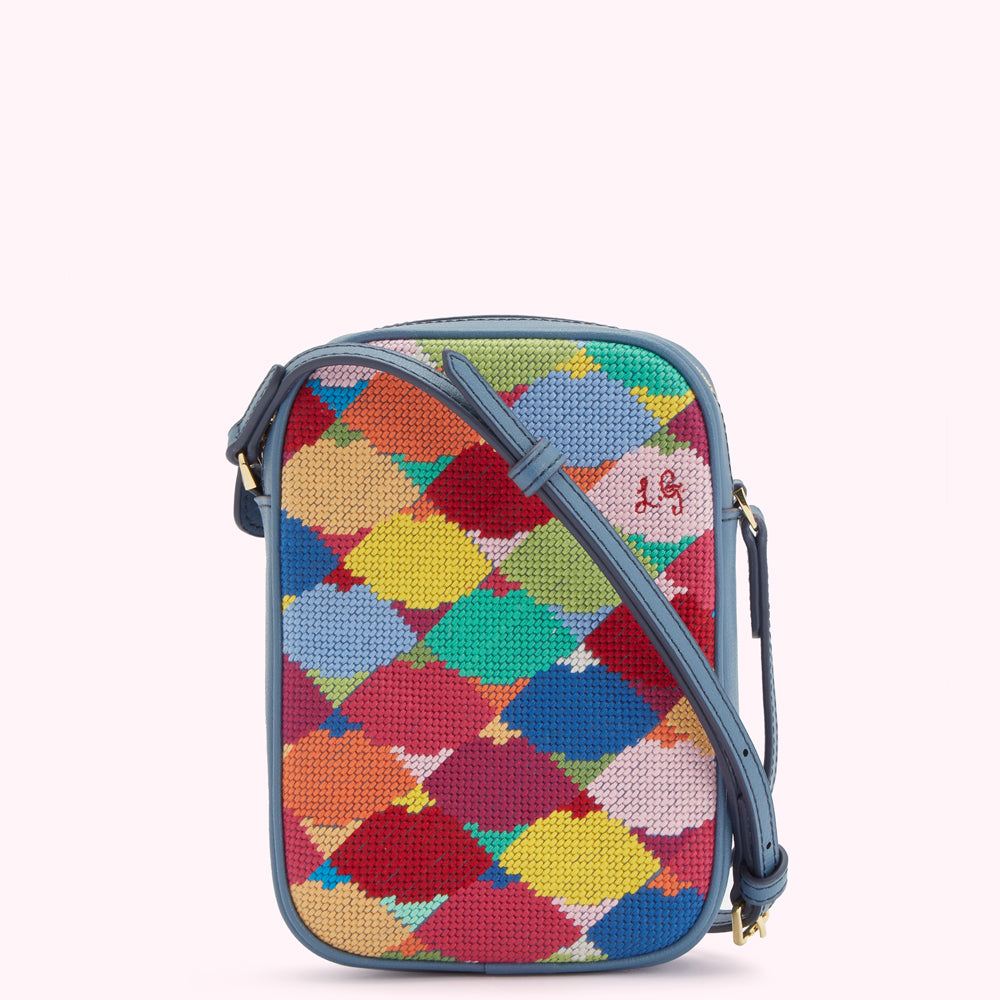 Multicolored needlepoint crossbody bag with blue leather trim and strap.