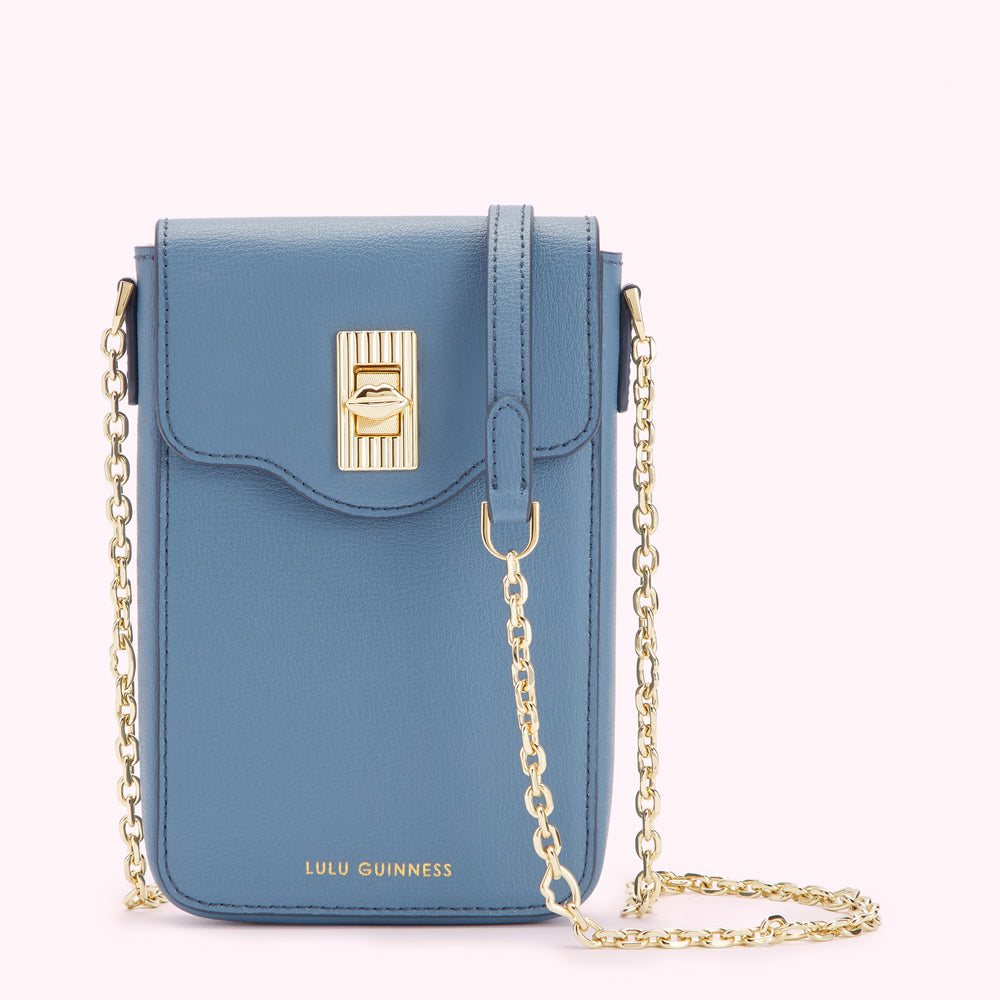 A powder blue Lulu Guinness crossbody bag with a gold chain strap and a gold lip-shaped clasp.