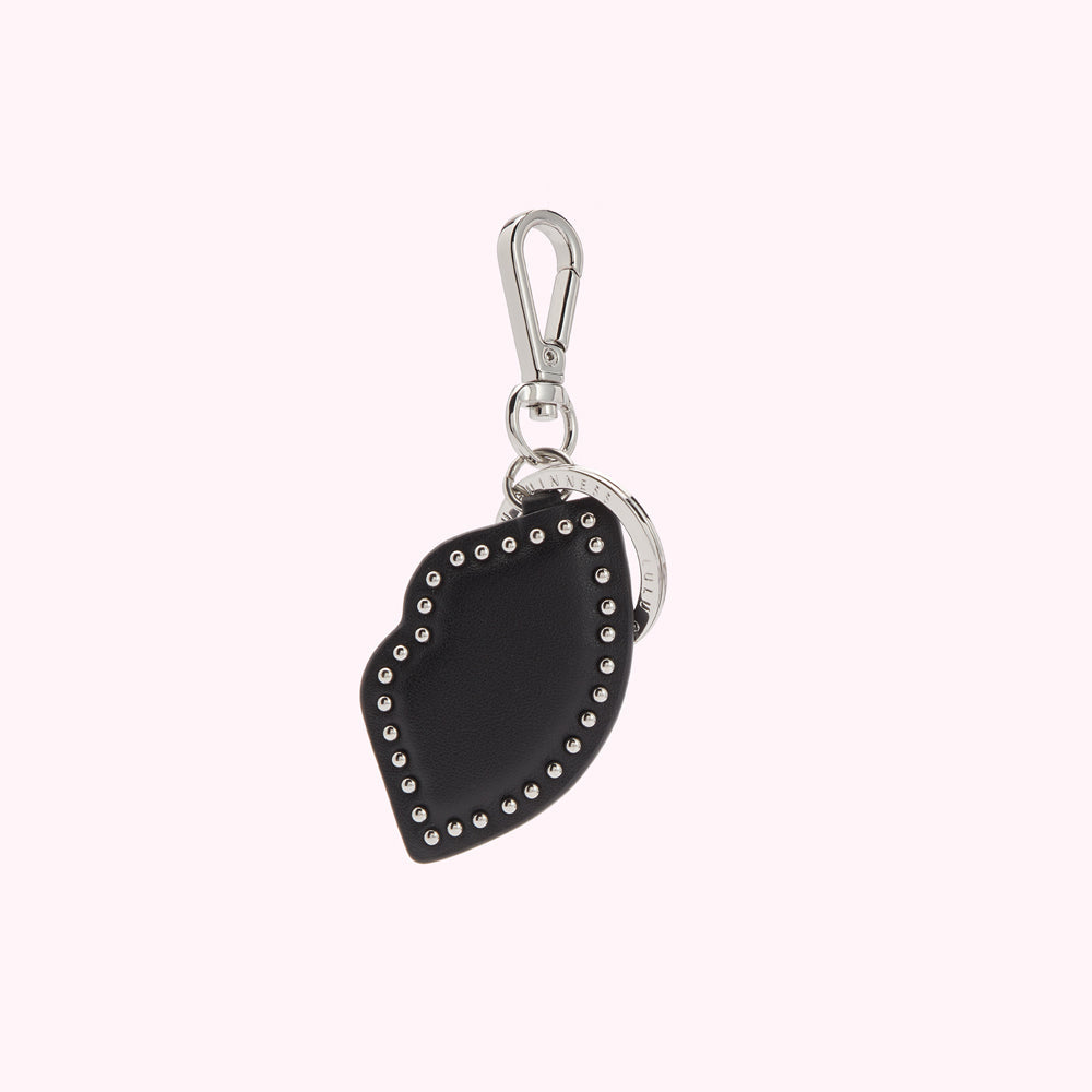 Black leather lip-shaped keychain with silver studs and metal ring.
