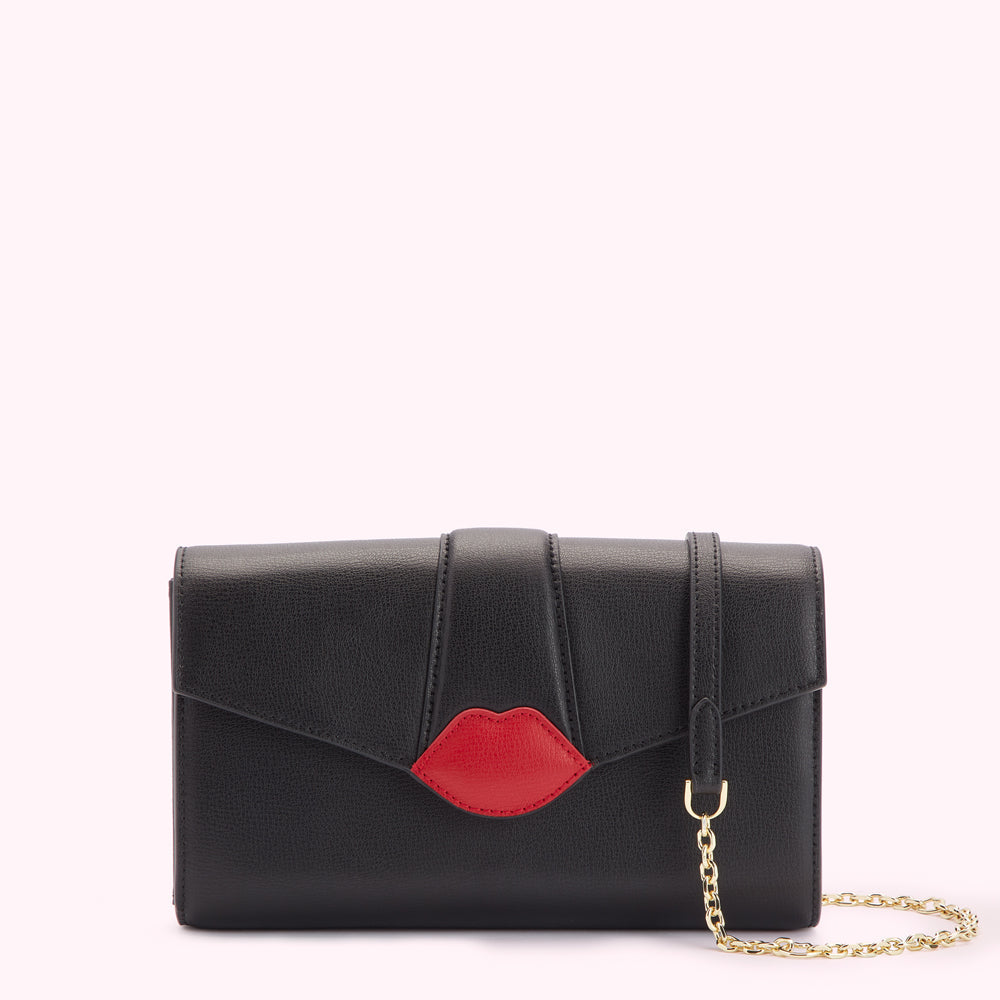 Black leather clutch with a red lip detail and gold chain strap.