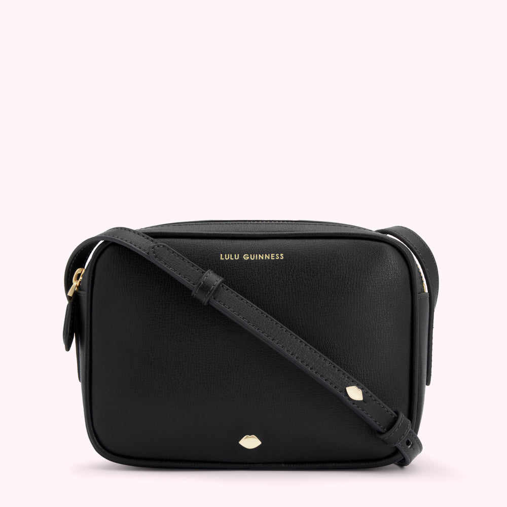 Black Lulu Guinness crossbody bag with gold logo and lip detail.