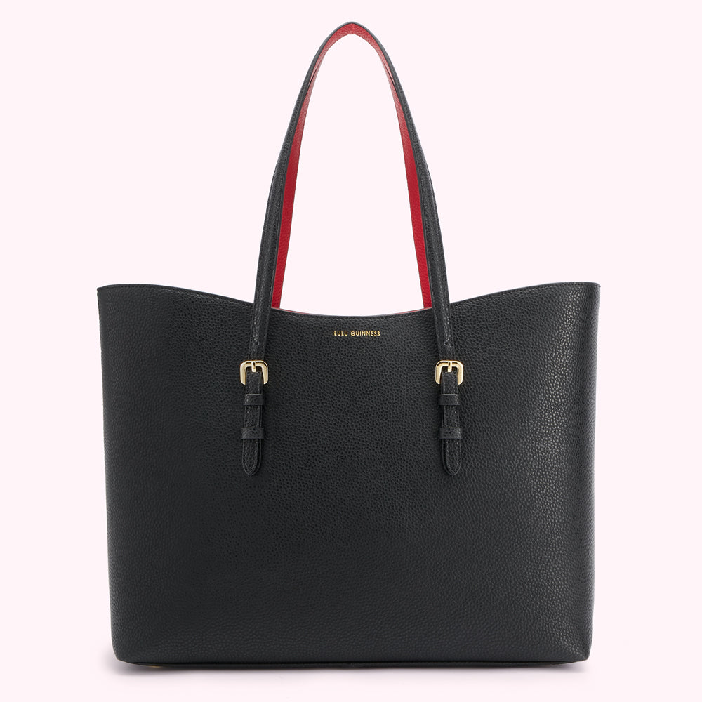 Black Lulu Guinness tote bag with red interior and gold buckles against a white background.
