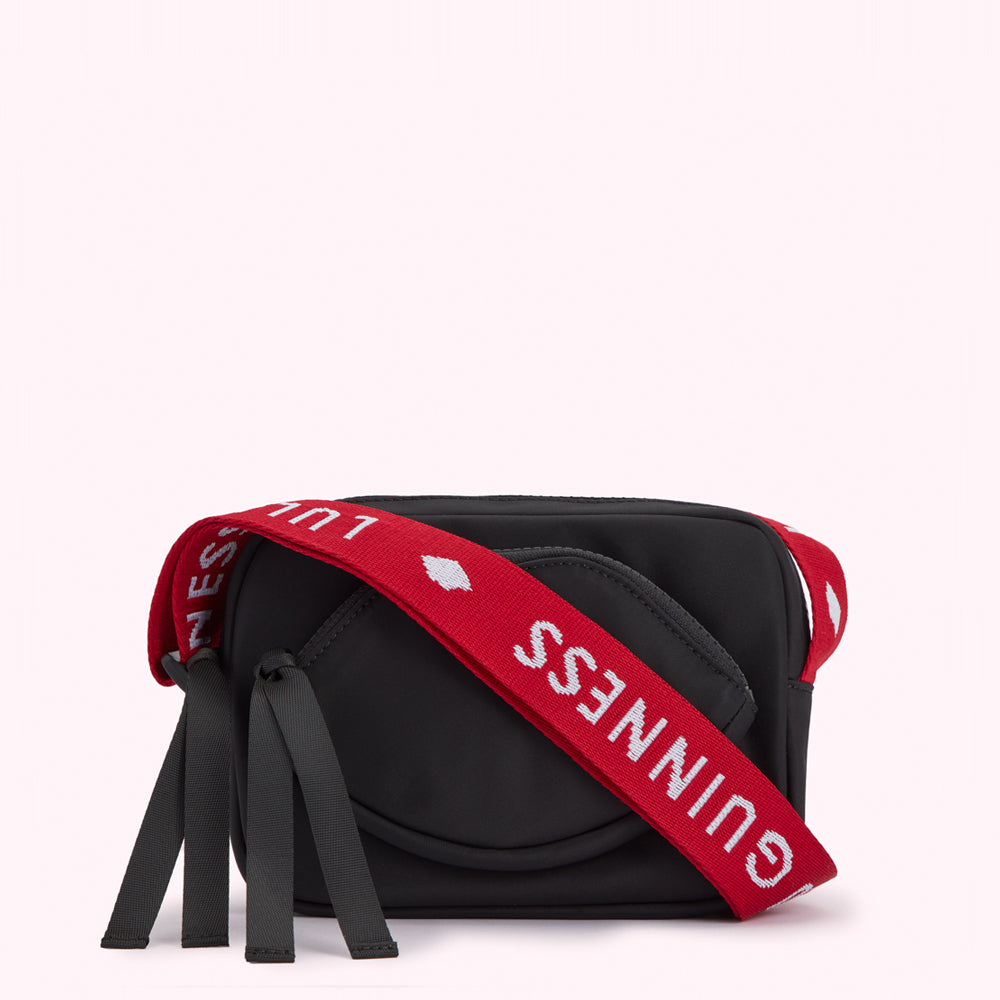 Black crossbody bag with red and white Lulu Guinness branded strap.