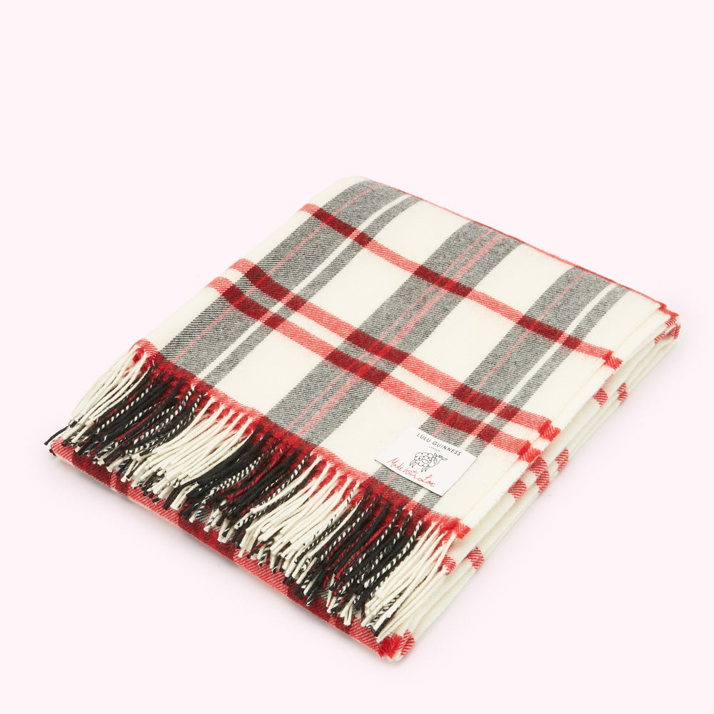 Cream, red, and grey plaid or tartan throw blanket with black and cream fringe. Lulu Guinness label visible.