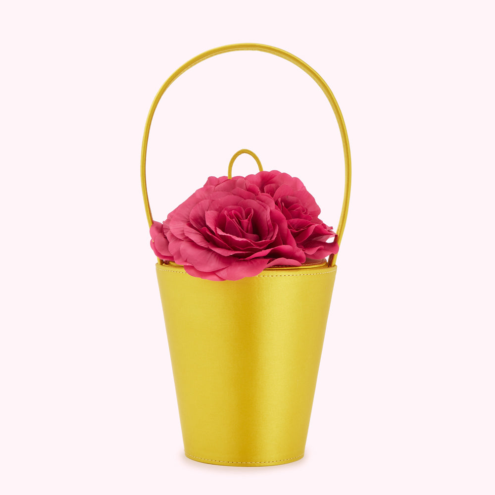 A chartreuse yellow bucket bag with a top handle, adorned with a cluster of fuchsia roses.