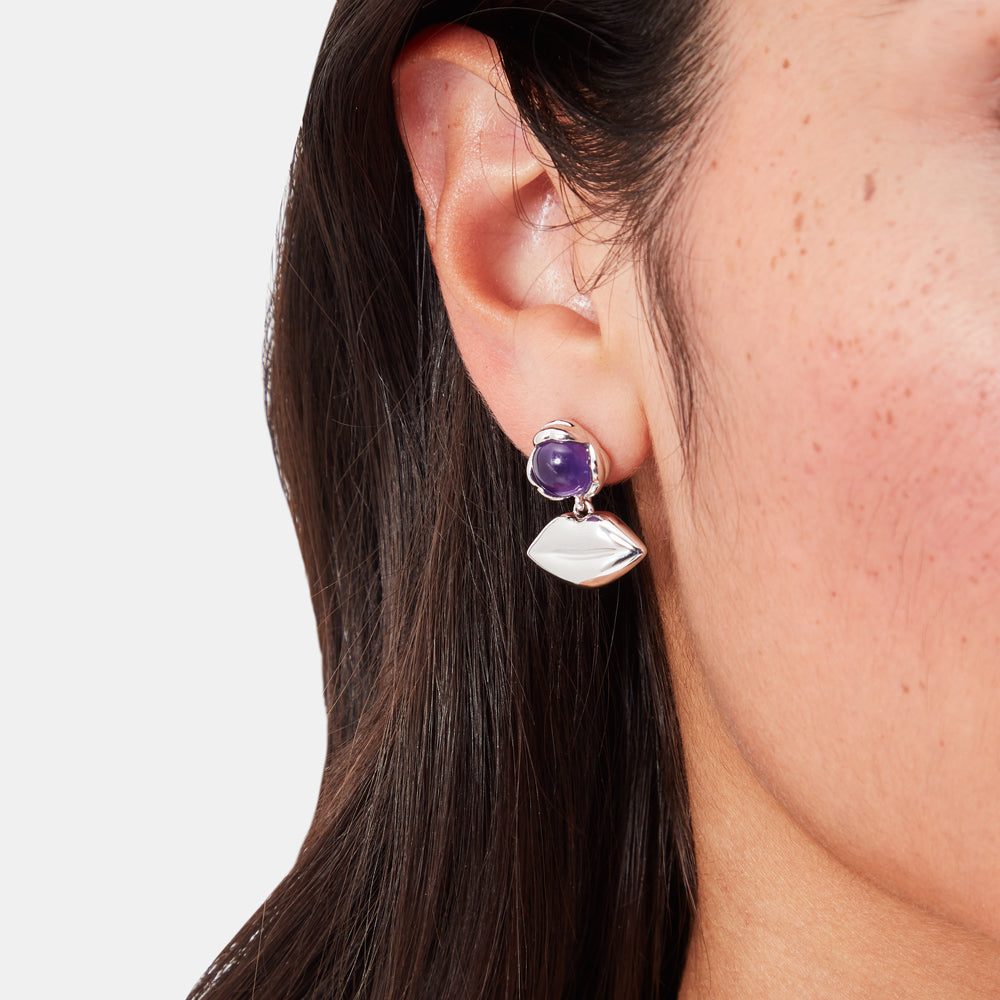 Silver lip-shaped earrings with purple amethyst stones.