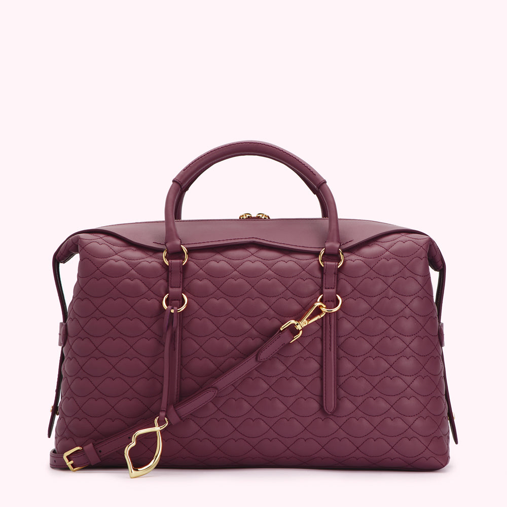 A burgundy quilted leather handbag with gold accents and a heart-shaped clasp on the strap.