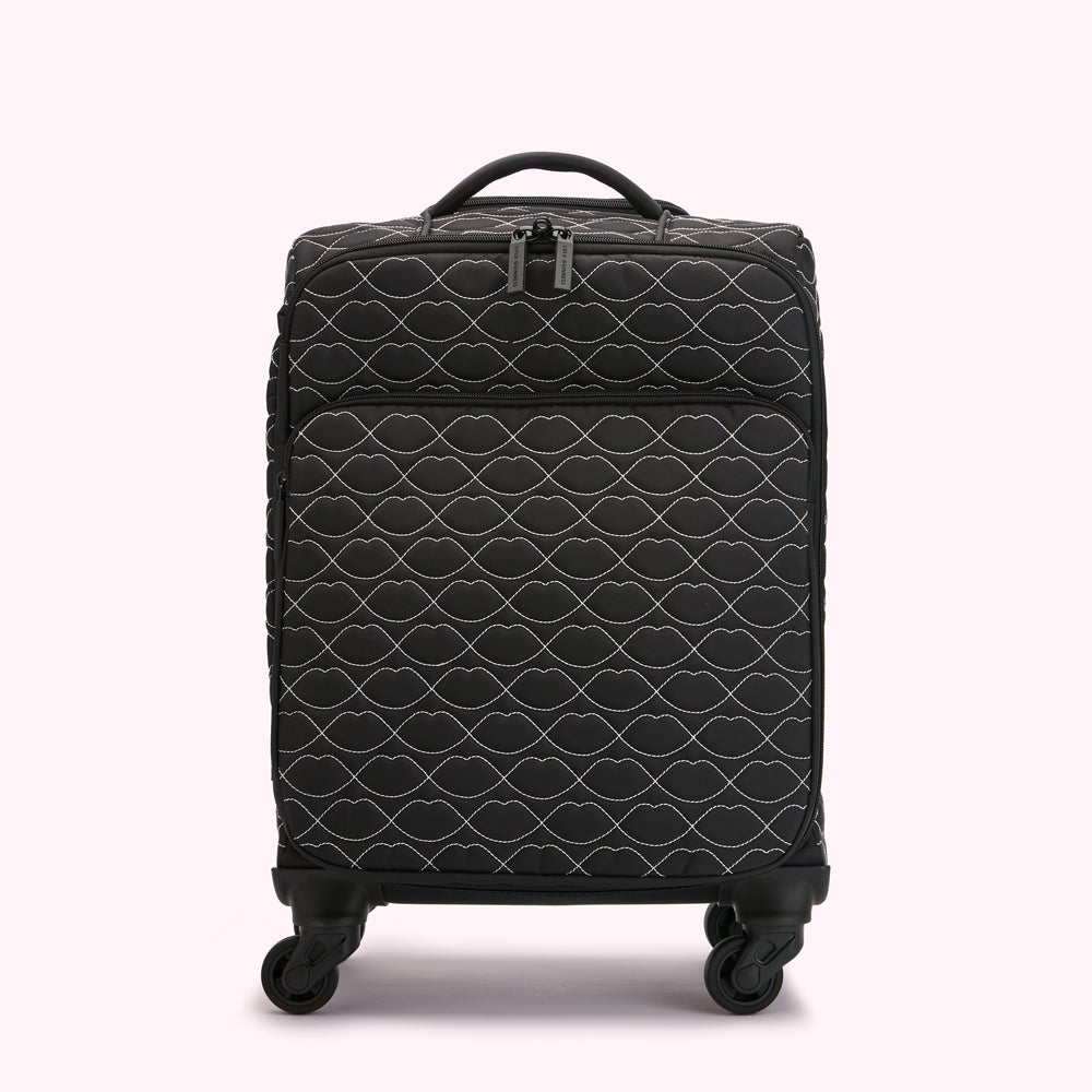 Black carry-on suitcase with a quilted pattern of white lips.