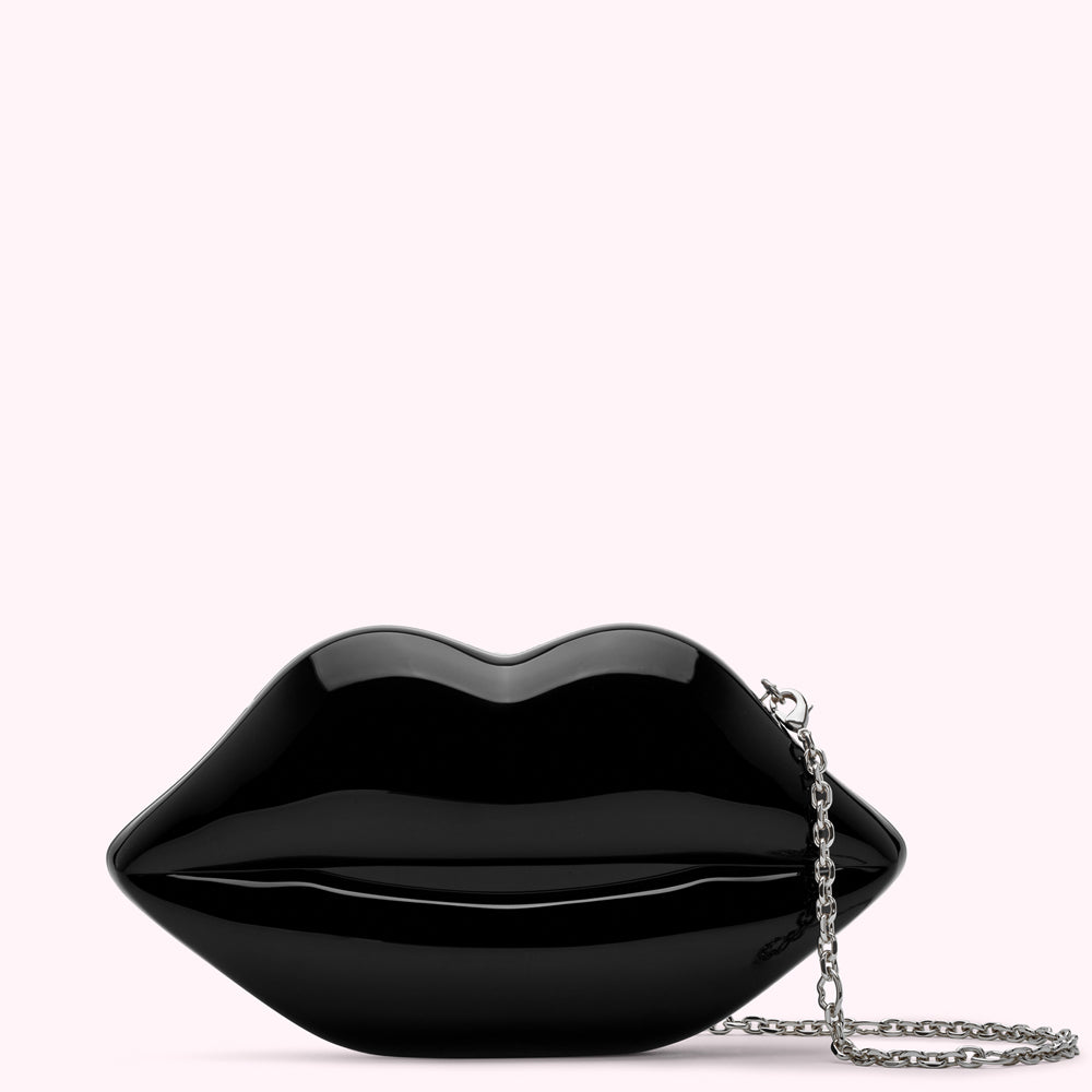 Black lip-shaped clutch with a silver chain strap against a white background.