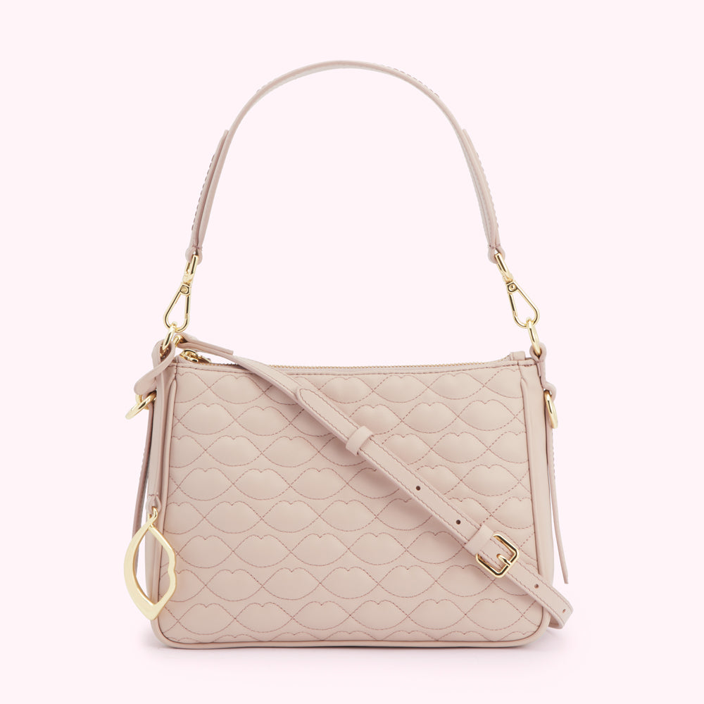 A blush-pink quilted crossbody bag with gold hardware and a lip-shaped pattern.