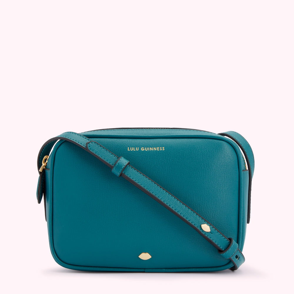 Teal Lulu Guinness crossbody bag with gold lettering and a gold lip detail.