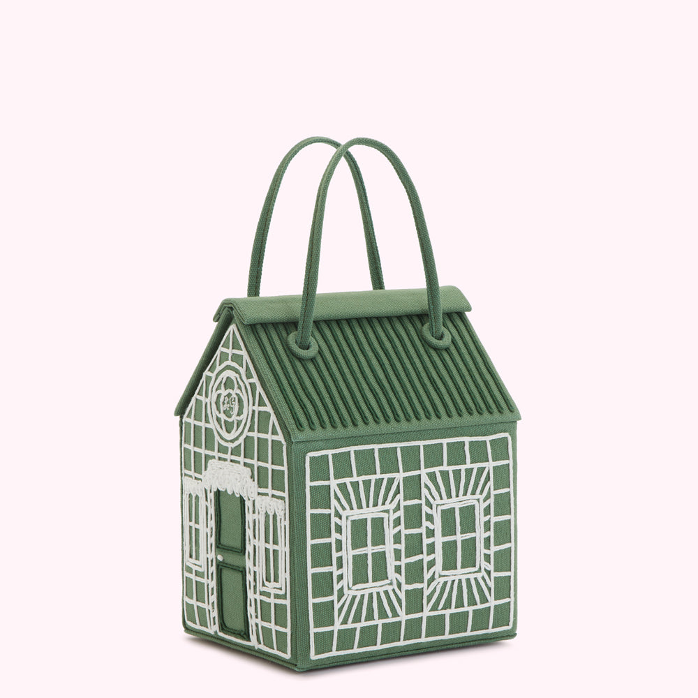 A sage green house-shaped handbag with white embroidered details.