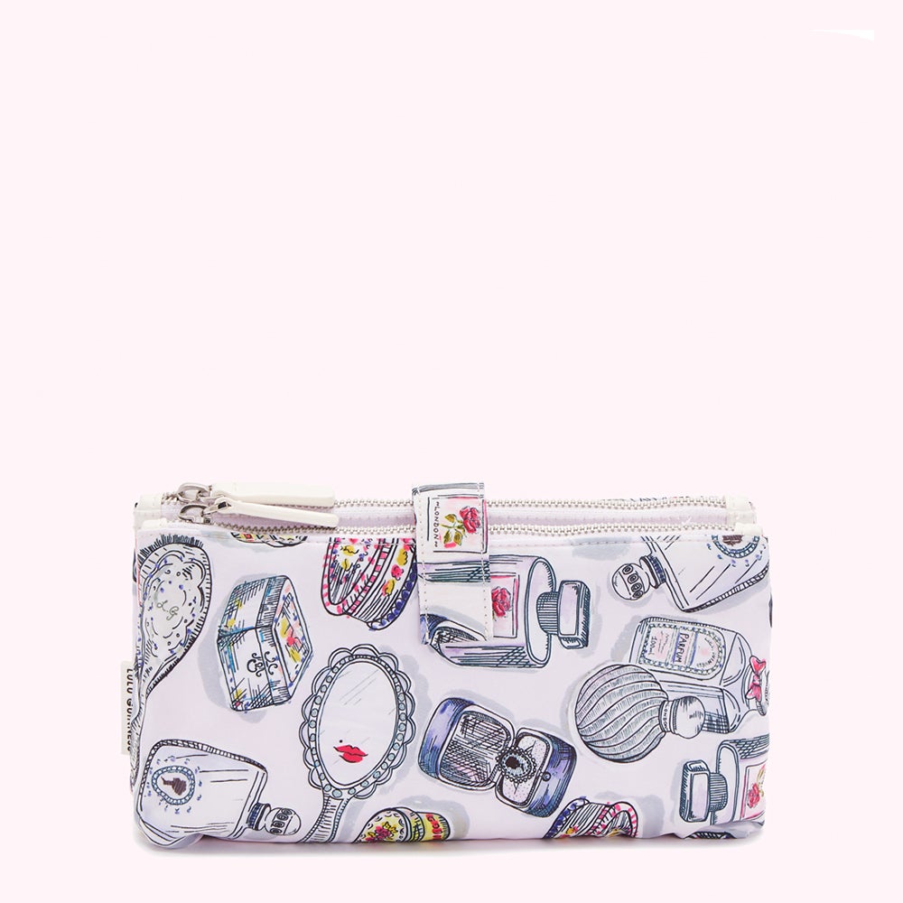 Double zippered cosmetic bag on a white background, featuring a lavender base with a repeating pattern of hand-drawn perfume bottles, compacts, and vanity mirrors.