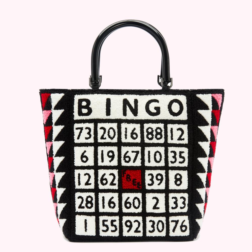 Black tote bag with a bingo card design. The bag features a black background with white and red numbers and pink and black triangles on the sides. The handle is black.