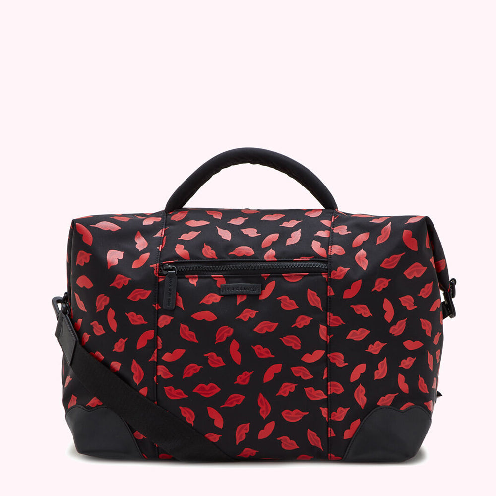 Black duffel bag with red lips pattern.