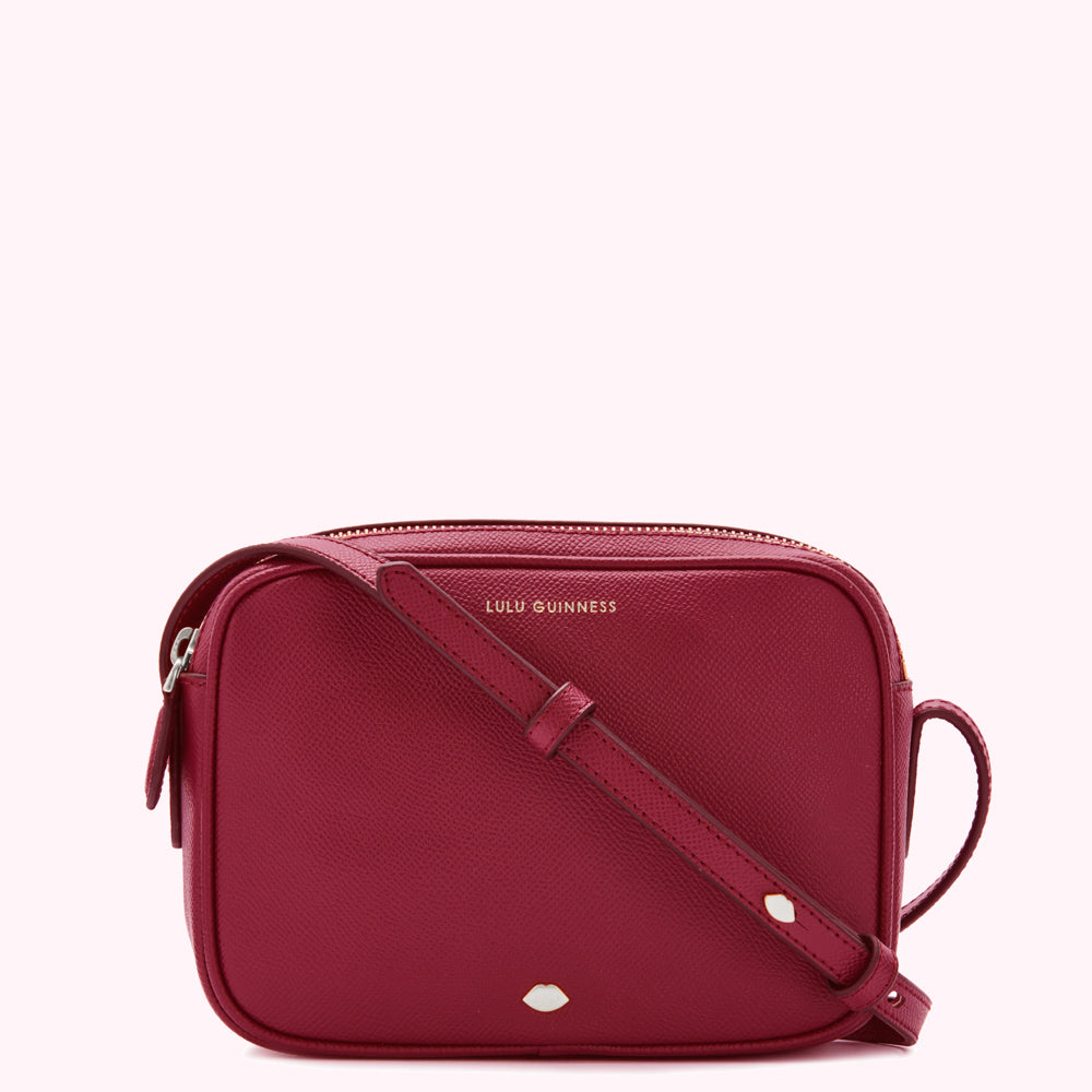 Pink Lulu Guinness crossbody bag with gold zipper and logo.