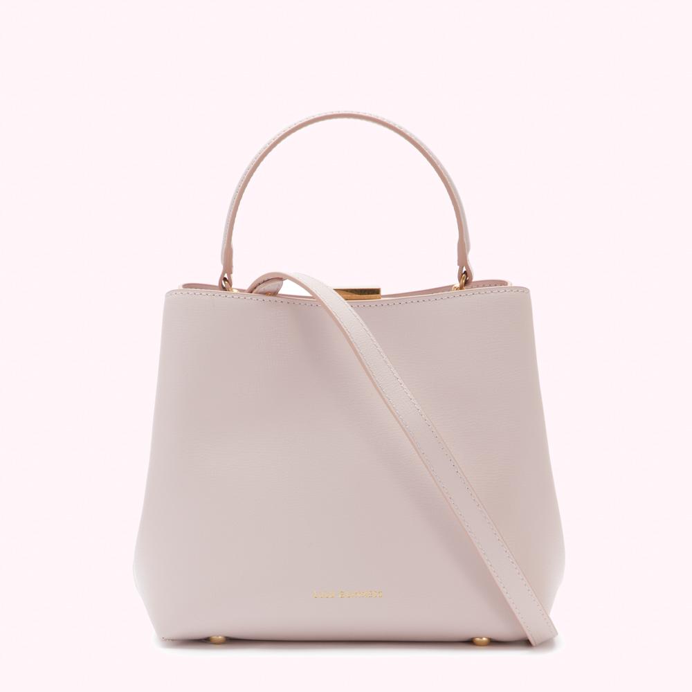 A pale pink leather handbag with a top handle and a shoulder strap.