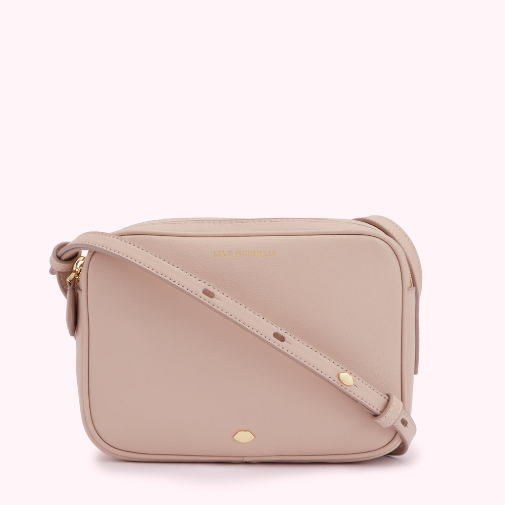 A blush pink crossbody bag with a gold logo and clasp.