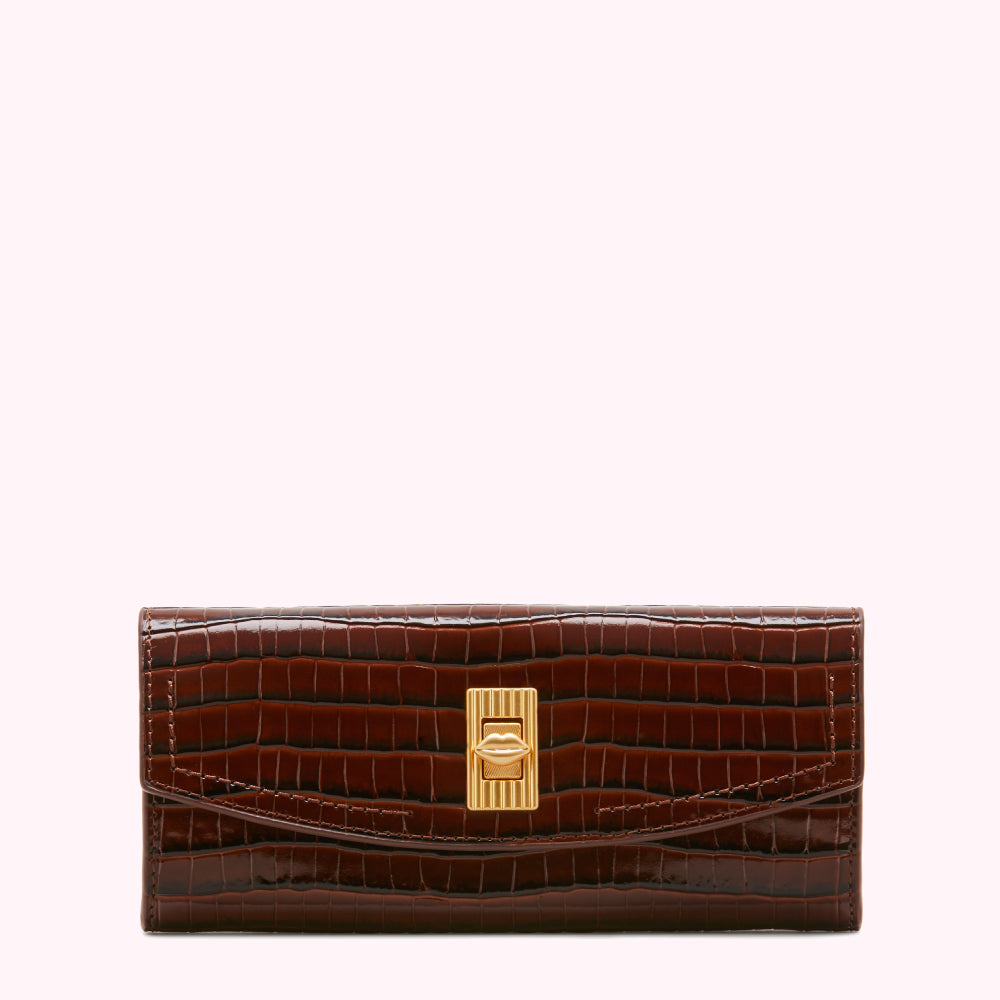 Brown crocodile-embossed leather wallet with gold lip-shaped clasp, on white background.