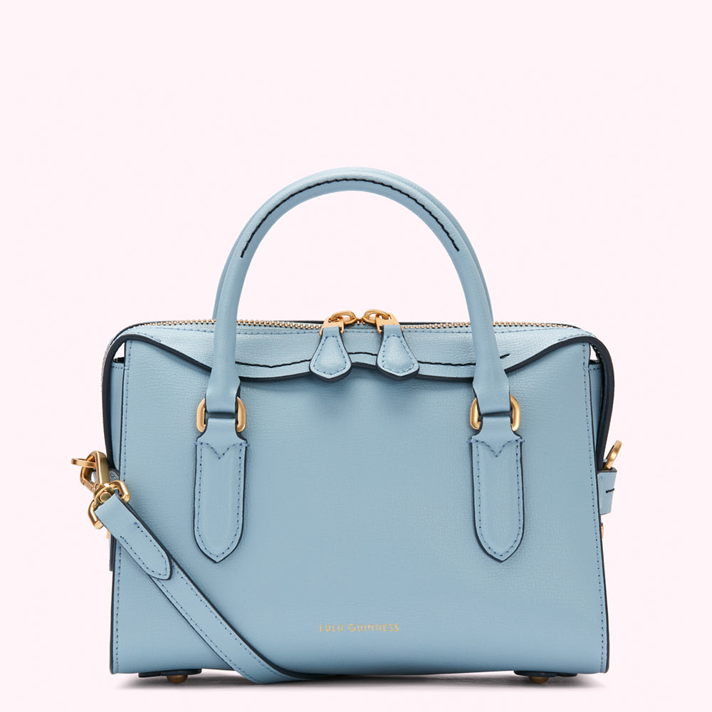 Light blue leather handbag with gold hardware and a crossbody strap. The brand name is subtly visible on the bottom.