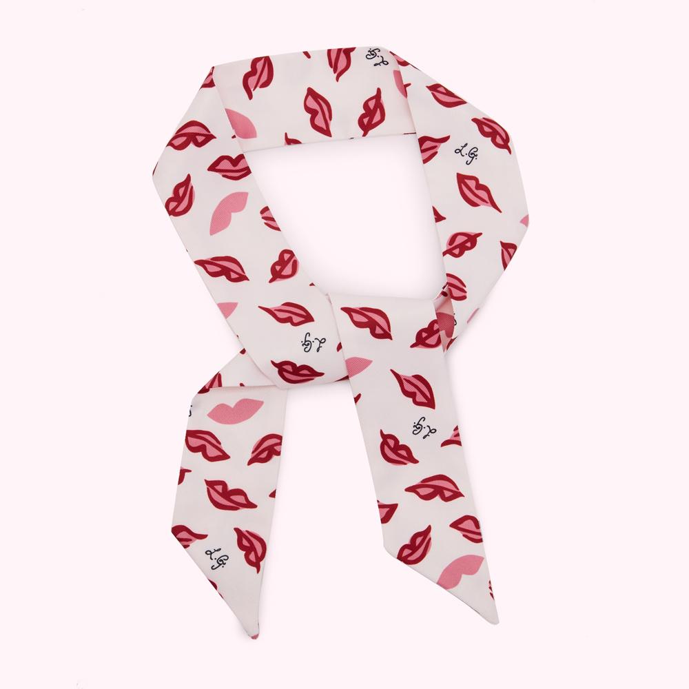 Pale pink silk scarf with a pattern of red lips and a logo.