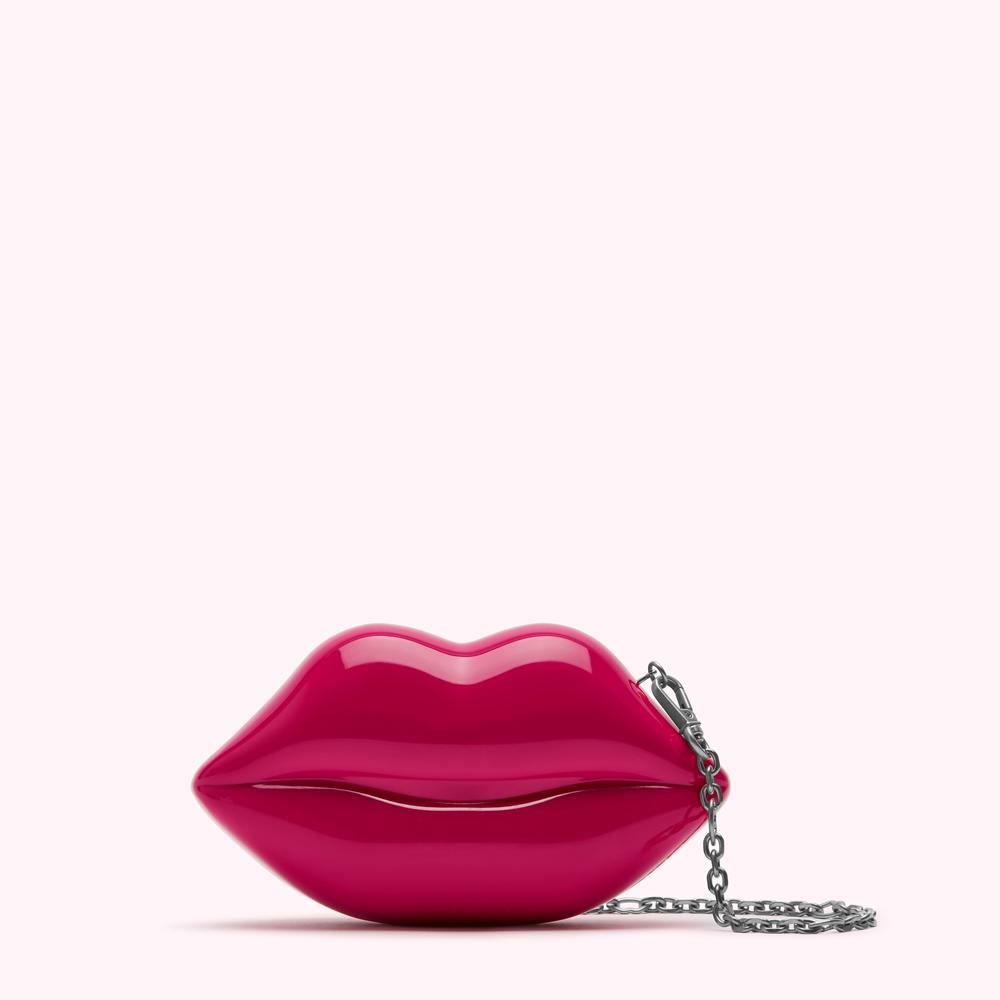 Pink lips-shaped clutch with a silver chain strap against a white background.