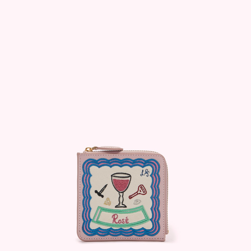 Pink leather zip-around wallet with embroidered rose-themed design.