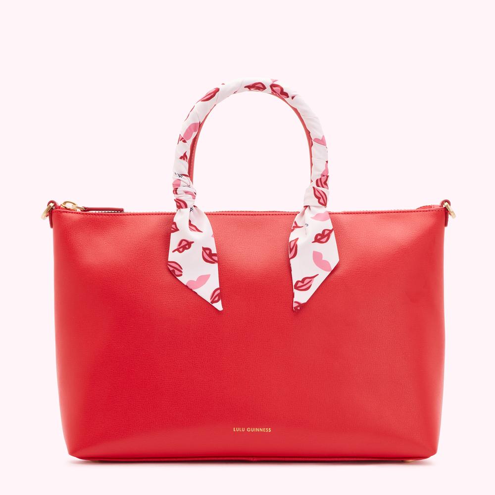 Red Lulu Guinness tote bag with a white lip-print scarf handle.