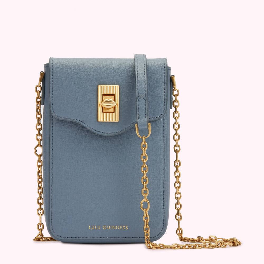 Dusty blue Lulu Guinness crossbody bag with gold chain strap and lip-shaped clasp.