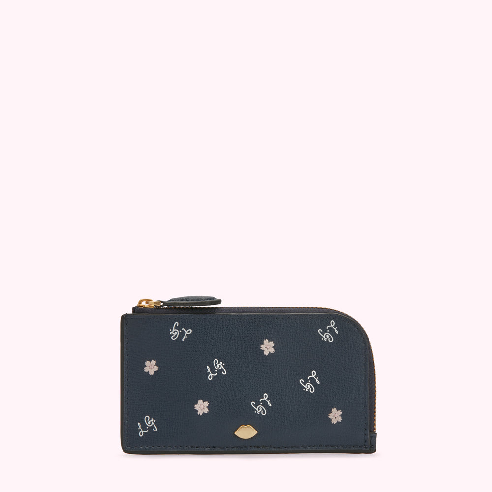 Dark blue leather cardholder with gold zipper and embroidered flowers and script.