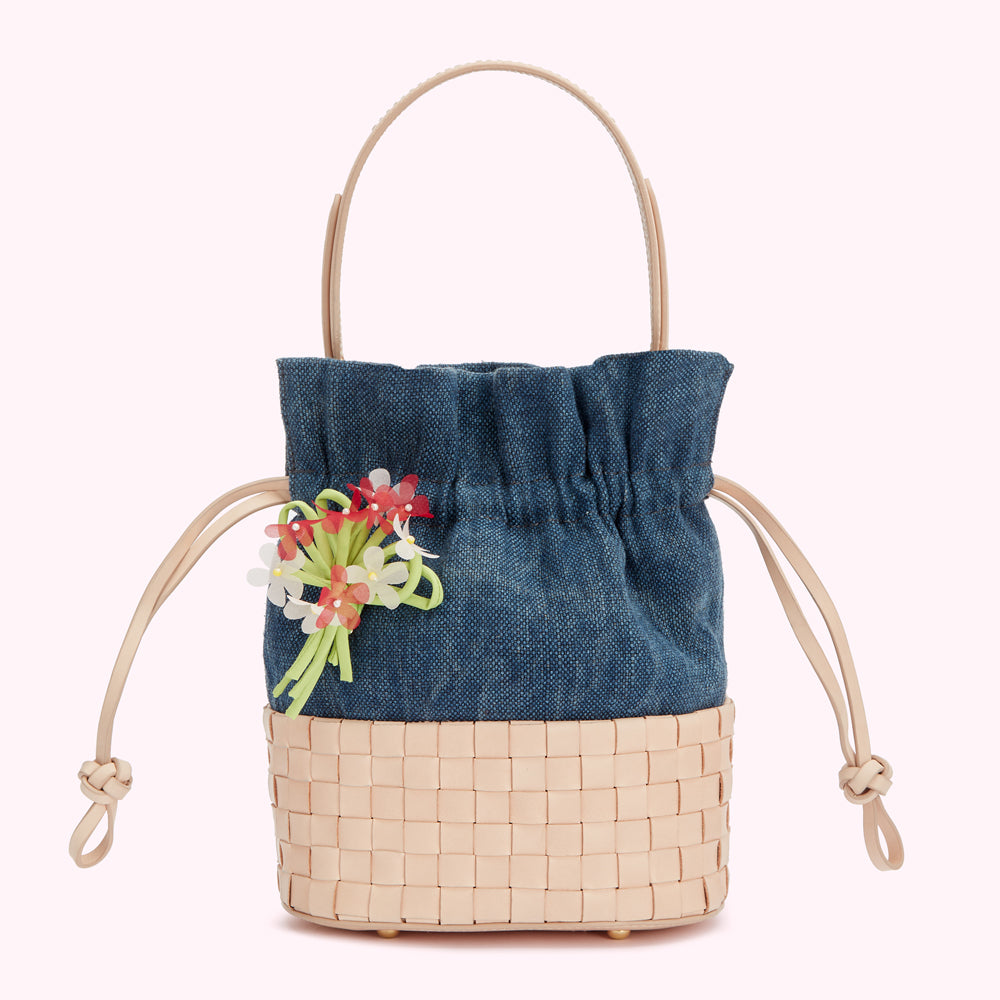 Small denim and woven bucket bag with a floral embellishment.