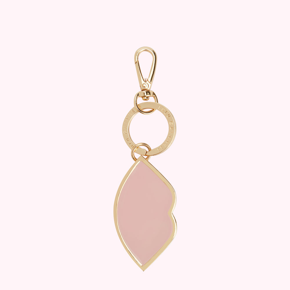 Pink lip-shaped keychain with gold accents and Lulu Guinness branding.