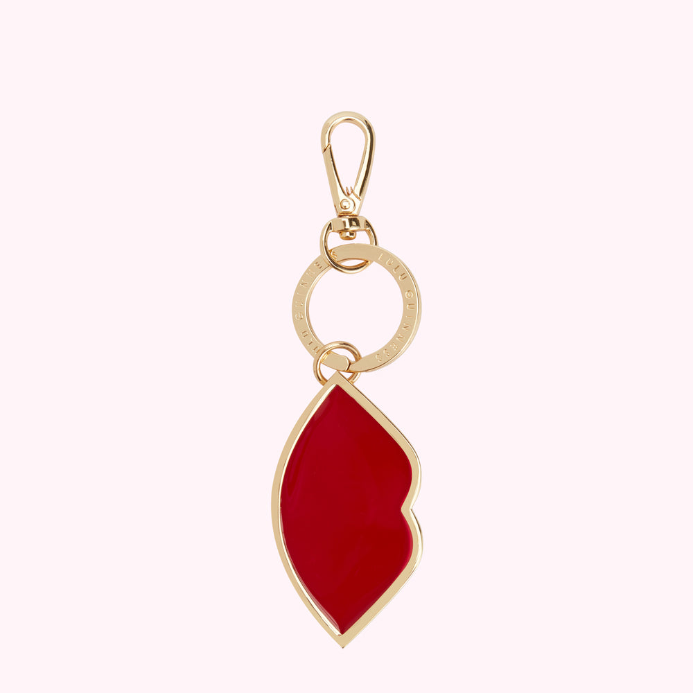 Gold Lulu Guinness keyring with red lip charm.