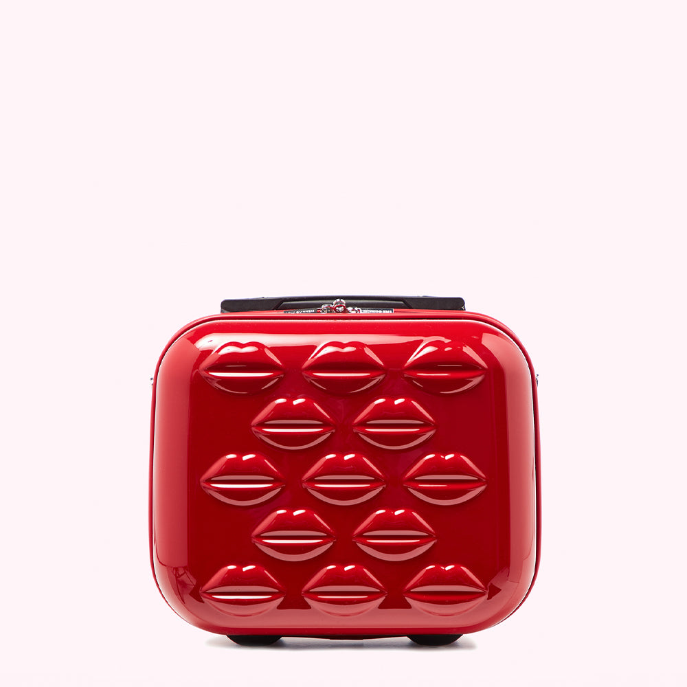 Red carry-on suitcase decorated with embossed lips.