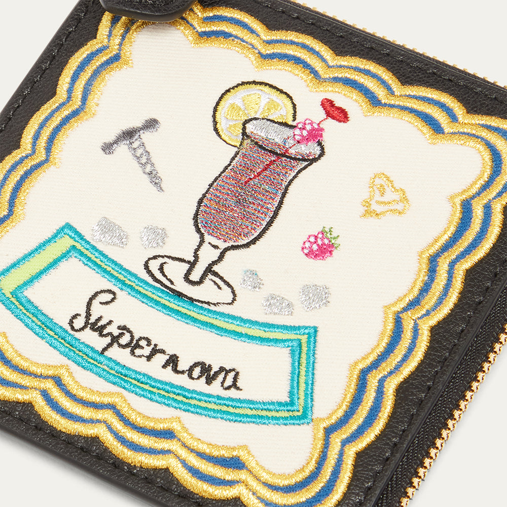 Embroidered design of a cocktail with 'Supernova' text on a coin purse.