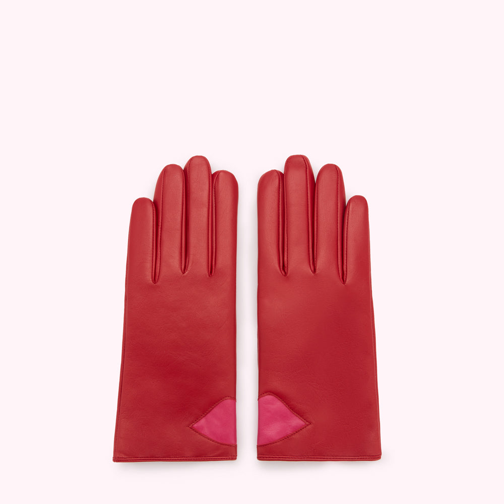 Pair of red leather gloves with pink lip detail against a white background.
