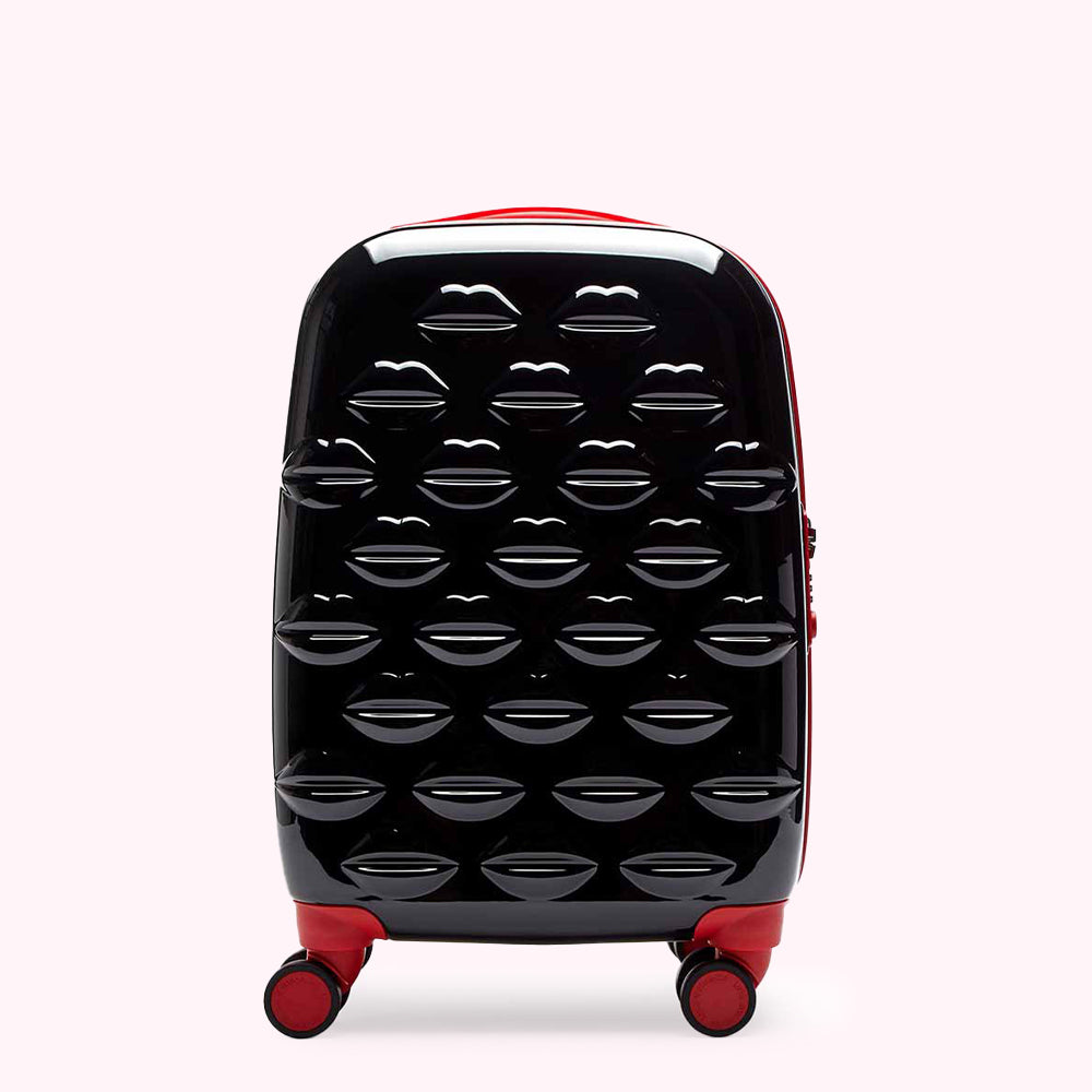 Black carry-on suitcase with red accents, covered in a pattern of glossy lips.
