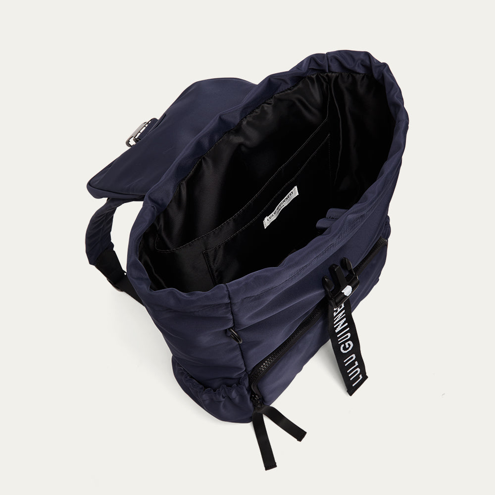 Navy blue backpack open showing the black lining on a light gray background