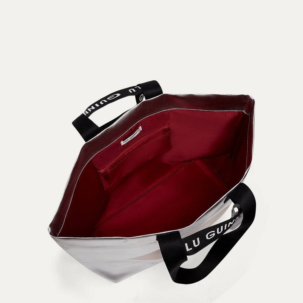 Tote bag with red interior and black handles on a white background