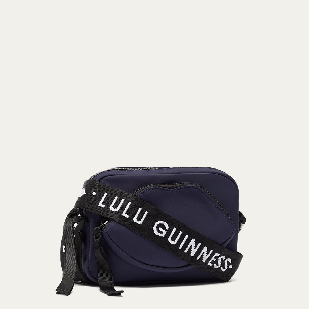 Navy blue bag with a black strap featuring 'Lulu Guinness' on a light gray background