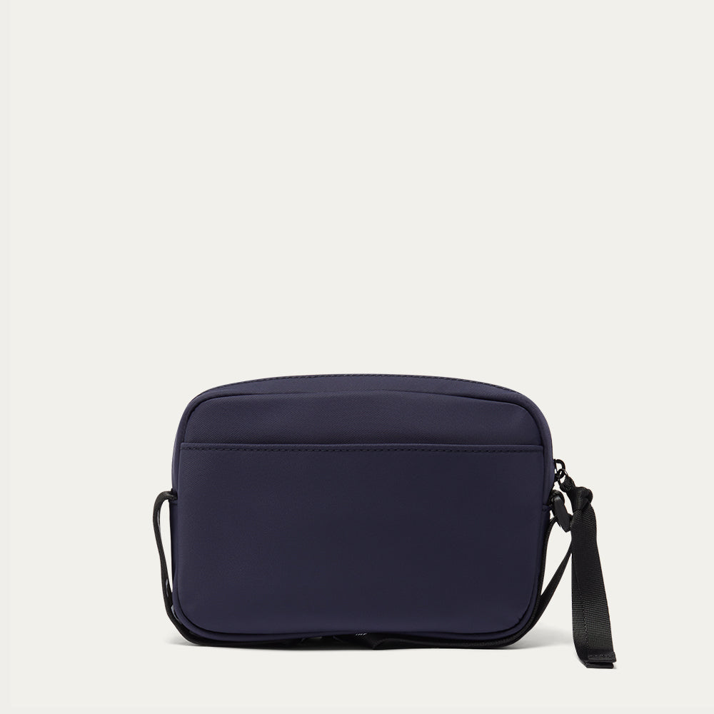 Navy blue crossbody bag on a light gray background