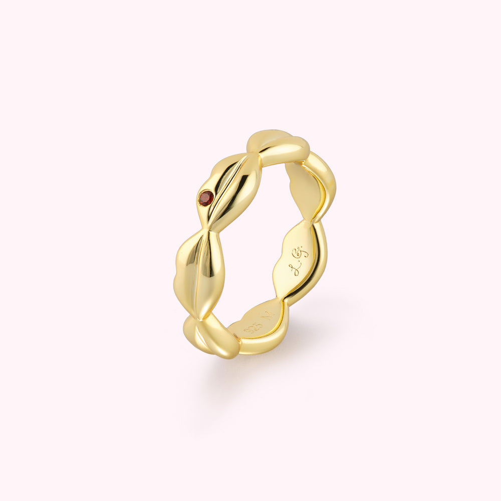 Gold lip shaped ring with inset ruby stone angled profile displaying engraved logo inside the band.